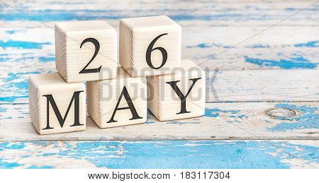 May 26th. Wooden cubes with date of 26 May on old blue wooden background.