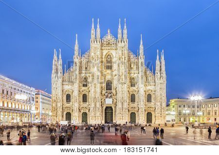 Milan Cathedral, Duomo di Milano. Famous gothic cathedral church of Milan, Italy, Europe. Black and white image shot at dusk from square full of people.