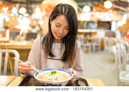 Woman enjoy her japanese ramen in restaurant
