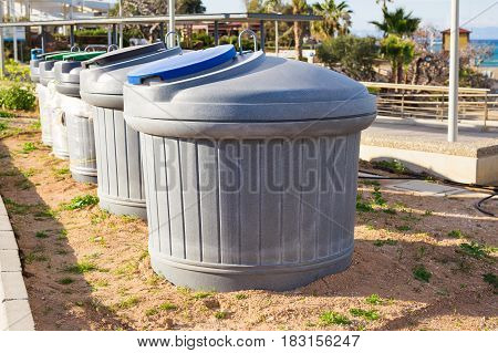 City trash cans. Green overfilled trash dumpster