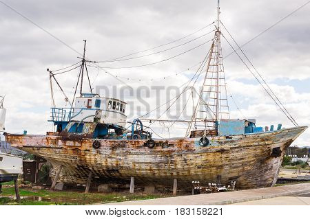 Abandoned broken ship-wreck beached on rocky sea shore