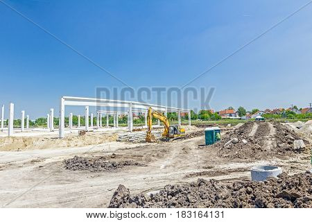 Architecture concept concrete skeleton of a new edifice with mobile plastic toilet.