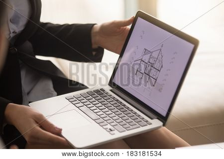Close up of laptop in female hands with architectural plan of two story house on the screen. Realtor or building company agent showing house section cut drawing, offering property for sale