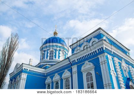 Old blue-white church with blue sky and clouds