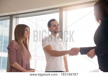 Man and woman came to the office to get consultation. Business people shaking hands, before after successful negotiations, pleasant meeting with agent, notary or lawyer, greeting gesture