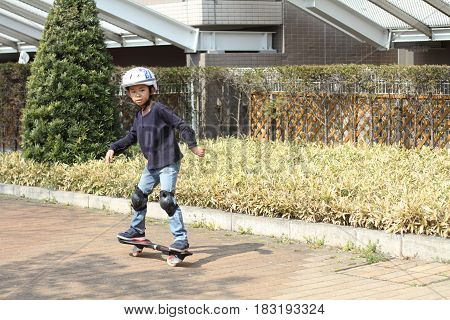 Japanese Boy Riding On A Casterboard (first Grade At Elementary School)