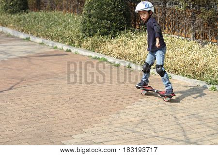 Japanese Boy Riding On A Casterboard (first Grade At Elementary School)