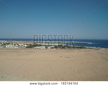 Blue Sea surrounded by Beach sands and Blue Skies