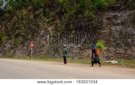 HA GIANG VIETNAM - SEP 26 2016. Hmong people walking on countryside road to coming home after finish work in Ha Giang north of Viet Nam.
