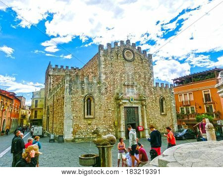 Taormina, Sicily, Italy - May 05, 2014: The people near Duomo Catherdal in Taormina city in Sicily. Cathedral of Taormina is a medieval church dedicated to St Nicholas of Bari or San Nicola di Bari