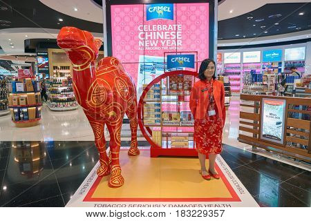 DUBAI, UAE - CIRCA JANUARY, 2017: promouter in red asian style clothing at Dubai International Airport. The airport is home to the long-haul carrier Emirates.