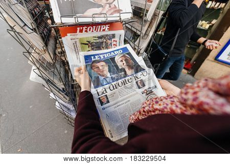 PARIS FRANCE - APRIL 24: Point of view Woman buy looks at press kiosk at French newspaper Le Figaro with pictures of French Presidential election candidates Emmanuel Macron Marine Le Pen a day after first round of French Presidential election on April 23