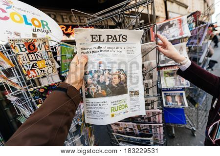PARIS FRANCE - APRIL 24: Man point of view persoanl perspective buy looks at press kiosk at Spanish newspaper El Pais with pictures of French Presidential election candidates Emmanuel Macron Marine Le Pen a day after first round of French Presidential ele