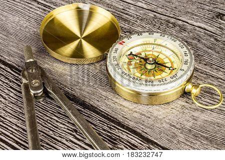 tourist compas and circinus on gray wooden table