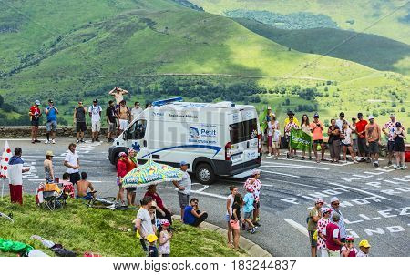 Col de PeyresourdeFrance- July 23 2014: The official ambulance climbing the road to Col de Peyresourde in Pyrenees Mountains during the stage 17 of Le Tour de France on 23 July 2014.