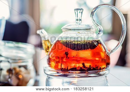 Close-up of modern glass teapot with tea inside in cafe