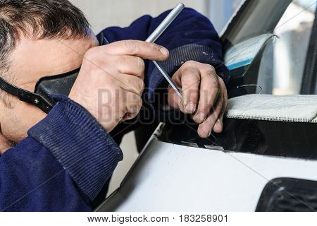 Repair cracked windshield. Car mechanic is repairing cracks in the glass.