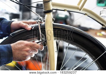 The man exchanges the brake pads on the bike