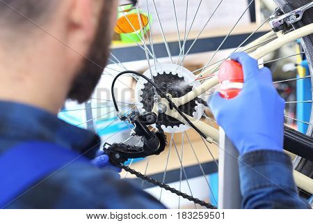 Bicycle service, installation derailleur
Man tightens and lubricates the derailleur in the bike
Serviceman. The man repairs the bike.