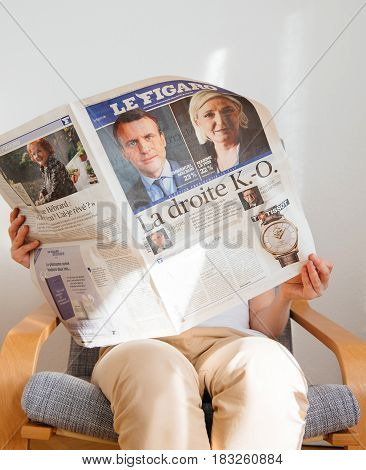 PARIS FRANCE - APR 24 2017: Emmanuel Macron on newspaper cover - woman reading the French newspaper Le Figaro a day after the first round of the French Presidential election on April 24 2017