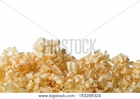 Light brown wood shavings from carpenter's hand planer or chisel work on wooden boards isolated on white background with copy space