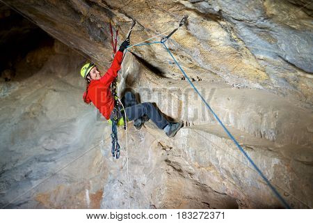 Speleologist performing rope maneuvers in a cave. Zaragoza Province, Aragon, Spain.