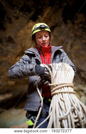 Speleologist performing rope maneuvers in a cave. Zaragoza Province, Aragon, Spain.