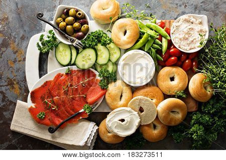 Big breakfast platter with cream cheese, bagels, smoked salmon and vegetables
