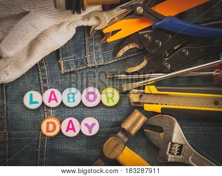 Labor day background concept - Jeans many handy tools with labor day text on Jeans background top view