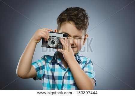 child taking a picture using a retro rangefinder camera isolated grey background.