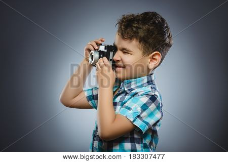 child taking a picture using a retro rangefinder camera isolated grey background.