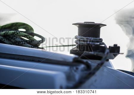 Capstan with line on a sailboat with white background.
