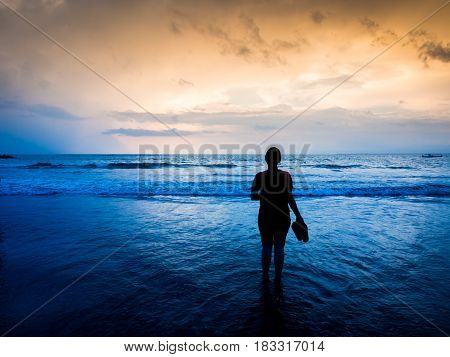 Silhouette of woman holding slippers . .