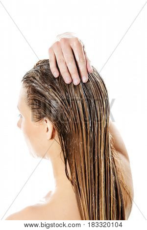 Photo of woman applying hair conditioner.