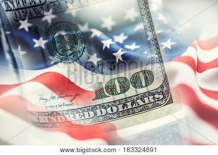 USA flag and American dollars. American flag blowing in the wind and 100 dollars banknotes in the background.