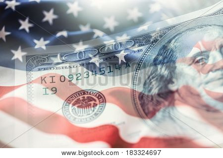 USA flag and American dollars. American flag blowing in the wind and 100 dollars banknotes in the background.