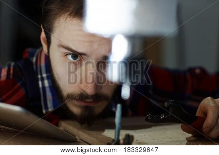 Young service worker with wrench repairing machine