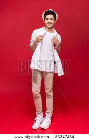 Full length of elegant young handsome asian man with hat. Cool fashion male model.