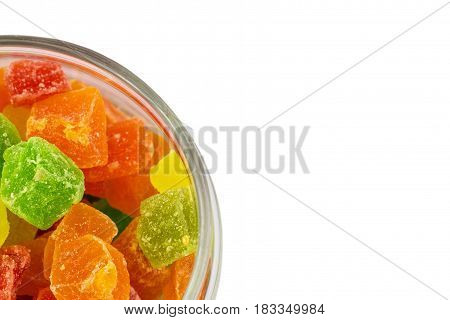 Sweet colorfful turkish delight in the opened glass jar top view on the left, isolated on white