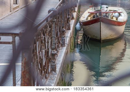 Simple Venice - Boat parked at the canal fence. Conceptual image from the brige. Italy