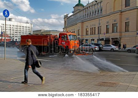 Moscow Russia - April 05 2017: Motion blurred photo of watering machine washes the road dust and dirt in Moscow