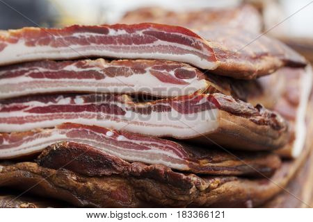 Very tasty smoked bacon cut into pieces selective focus and small depth of field