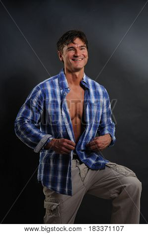 The handsome cowboy is laughing at something.