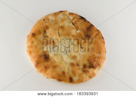 piece of khachapuri with meat lying on a white table