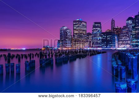 New York city skyline at night, Manhattan skyscrapers reflected in water, NY, USA