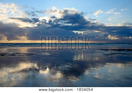 Nube riflessioni sulla spiaggia al tramonto.