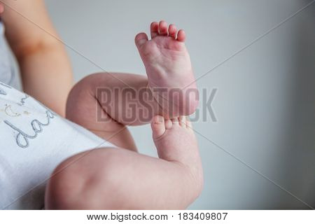 Tiny newborn infant male or female baby feet and toes