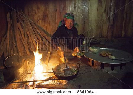 Sa Pa, Vietnam - 14 March, 2017: Ethnic minority, Hmong woman cooking in traditional kitchen in house of Hmong tribal village near Sapa, Vienam