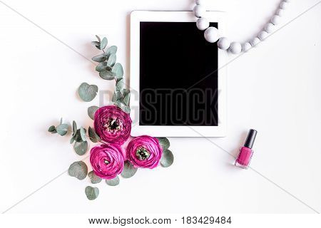 Modern spring design with bright pink flowers and tablet on white desk background top view moke up