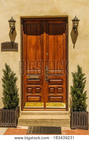 Double wooden doors and are flanked by twin light fixtures Philadelphia
